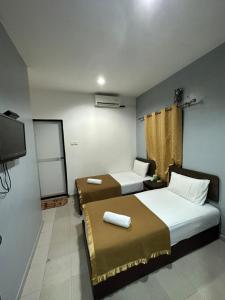 瓜埠ISLAND TIME MOTEL KUAH的客房设有两张床和一台平面电视。