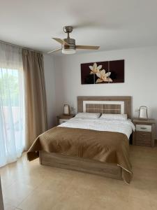 托雷帕切科Apartment in Mar Menor Golf Resort的一间卧室配有一张床和吊扇