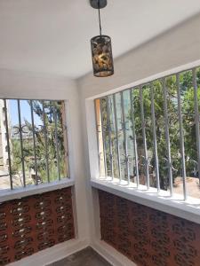 内罗毕Stellar 1-bedroom apartment in Madaraka Estate, Nairobi的客房设有2扇窗户和吊灯。