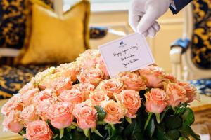 维也纳Hotel Imperial, a Luxury Collection Hotel, Vienna的手持粉红色玫瑰花花花花标牌的人