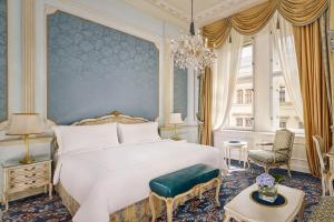 维也纳Hotel Imperial, a Luxury Collection Hotel, Vienna的卧室配有一张白色大床和吊灯。
