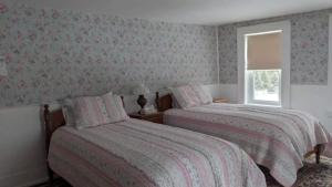 FrancestownBlue Bear inn的一间卧室设有两张床和窗户。