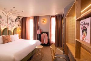 巴黎Hôtel Jardin de Cluny的酒店客房带一张大床和一把椅子