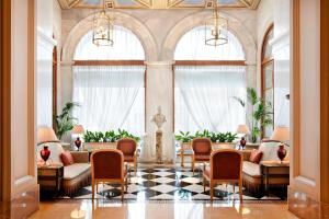 雅典Hotel Grande Bretagne, a Luxury Collection Hotel, Athens的大堂设有桌椅和窗户。