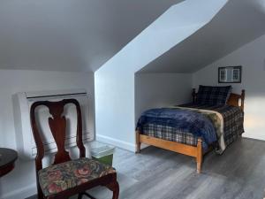 FrancestownBlue Bear inn的阁楼卧室配有床和椅子