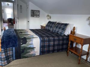 FrancestownBlue Bear inn的一间卧室配有一张床和一张桌子及床头柜