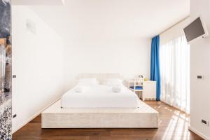 加尔达湖滨嘉比利酒店的一间白色的卧室,配有床和楼梯