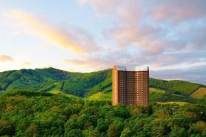 留寿都村留寿都威斯汀度假酒店的一座山丘上的建筑,有彩虹