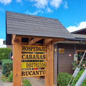 FreireHosteria y Cabañas Rucantu的房屋前面有标志