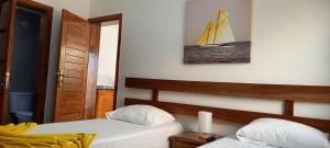 塔拉法尔Hotel Viajante的卧室配有两张床,墙上挂有帆船