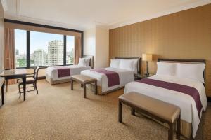 曼谷曼谷苏坤喜来登豪华精选大酒店的酒店客房设有两张床和大窗户。