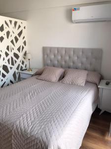 罗萨里奥Rosarioalquilertemporario的一间卧室配有一张带白色床头板的大床