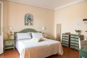 米兰马瑞提那Villa Arizona的一间卧室配有一张床、一个梳妆台和一扇窗户。