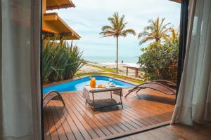 邦比尼亚斯Hotel Atalaia do Mariscal的阳台配有桌子,享有海滩美景