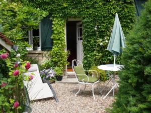 吉维尼A l'Ombre du Tilleul的一个带桌子和遮阳伞的庭院
