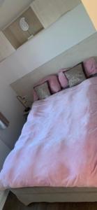 WesterlandLuxus Chalet Meeresweitblick的一张带粉红色床单和枕头的床