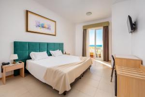 波尔蒂芒阿尔加维圣卡塔里娜酒店的一间带大床的卧室,享有海景