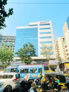 孟买Hotel Hilton Suites的一条繁忙的城市街道,有汽车、摩托车和公共汽车
