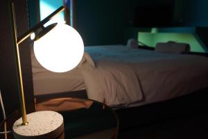 阿韦利诺Grand hotel irpinia & Family SPA的一间卧室配有一张床和一张带台灯的桌子