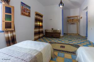 舍夫沙万Dar El Fanne的一间带两张床的卧室,铺有瓷砖地板。