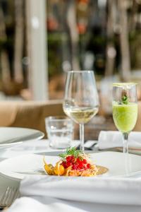 都拉斯Diamma Resort Conference & Spa的一张桌子,上面放着一盘食物和两杯葡萄酒