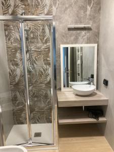马里纳迪马萨B&B Il Viaggiatore的带淋浴、盥洗盆和镜子的浴室
