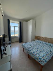 萨沃纳CasAmare di Carla的一间卧室配有一张床、一张书桌和一个窗户。