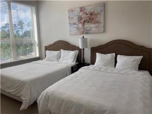 斯普林Resort Style Apartments in Spring, TX的一间卧室设有两张带白色床单的床和窗户。
