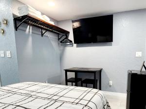 莱克兰Studio 3!的卧室配有一张床,墙上配有电视。