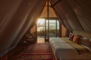 巴卡拉尔Our Habitas Bacalar的一间卧室设有一张床和一个大窗户