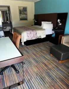 拉斐特Discovery Inn Lafayette的酒店客房,配有两张床和椅子