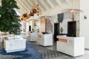 卢萨卡Ciêla, Lusaka, a Tribute Portfolio Resort and Spa的大堂设有白色柜台、树木和天花板。
