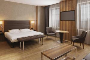 里加AC Hotel by Marriott Riga的一间酒店客房,配有一张床和一台电视