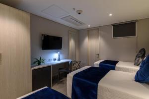 麦德林4 Sur Hotel的酒店客房配有两张床和一张书桌