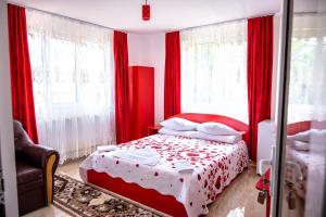 舒加塔格盐矿镇Pensiunea Larisa的红色卧室配有红色窗帘的床