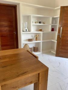 加利纽斯Casa Refúgio的用餐室配有木桌和白色架子