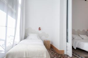 巴塞罗那安东尼精品旅馆的一间卧室配有两张床和镜子