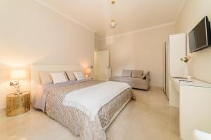 萨莱诺HomeAway Salerno的白色卧室设有一张大床和一张沙发