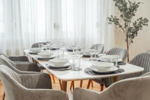 萨尔布吕肯LUXURY-Apartment - city center : 8 guests : Netflix的桌椅和白色桌子,配有盘子和玻璃杯