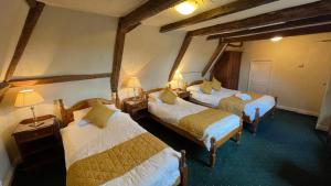 道纳姆马基特Crown Hotel的酒店客房设有三张床和两盏灯。