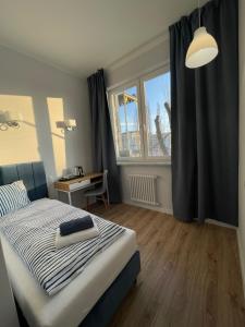 埃尔布隆格Aparthotel Dworzec的一间卧室配有一张床、一张书桌和一个窗户。