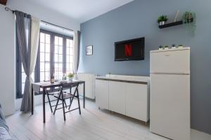 帕维亚CENTRO STORICO • Wi-Fi, Netflix e Terrazzo的厨房配有白色冰箱和桌子