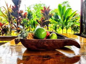 TaravaoTAHITI - Fare Matavai Hoe的木桌上的木碗水果