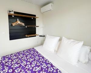 TaravaoTAHITI - Fare Matavai Toru的一间卧室配有一张带紫色毯子的床