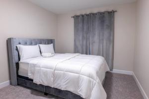 尼亚加拉瀑布Luxury Niagara 3 Bdr Townhouse /Garage的一间卧室配有一张大床和灰色床头板