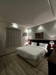 泰布克العنوان للإقامة بتبوك The Address Residence -Tabuk的一间卧室配有一张大床和两盏灯。