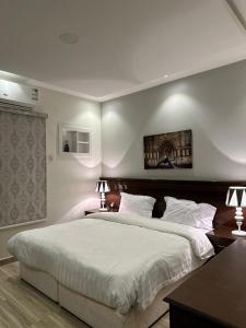 泰布克العنوان للإقامة بتبوك The Address Residence -Tabuk的一间卧室配有一张带两盏灯的大型白色床。