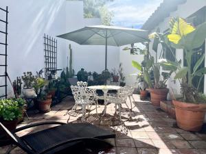 洛杉矶Hollywood Hills Homestay的天井配有桌子、雨伞和植物