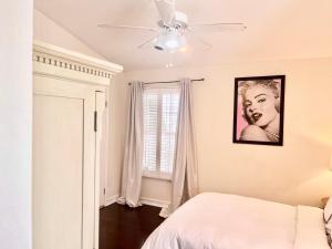 洛杉矶Hollywood Hills Homestay的一间卧室配有一张床和吊扇