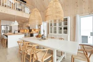 彻特西Chalet le Chardonnay - Spa , Foyers , Accès plage Lac-Jaune的厨房配有白色的桌椅